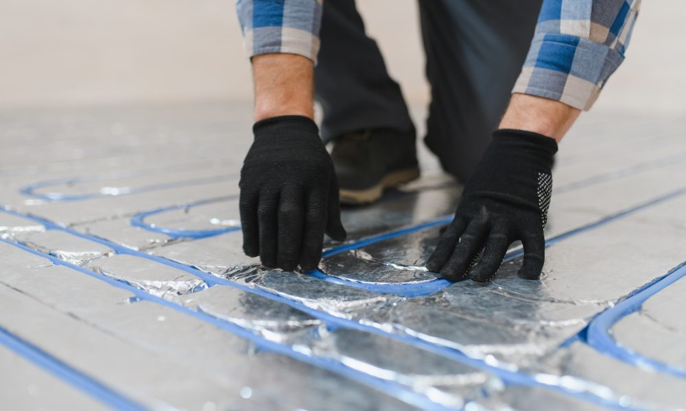 Master installs the overlapping thermal insulation in the room. Floor heating installation.